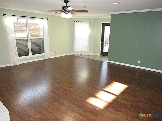 empty room featuring dark wood-style floors, ornamental molding, a ceiling fan, and baseboards