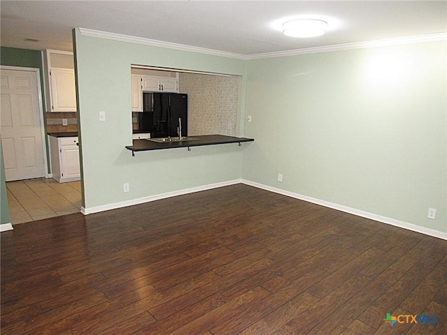 unfurnished living room with ornamental molding, dark wood-style flooring, and baseboards