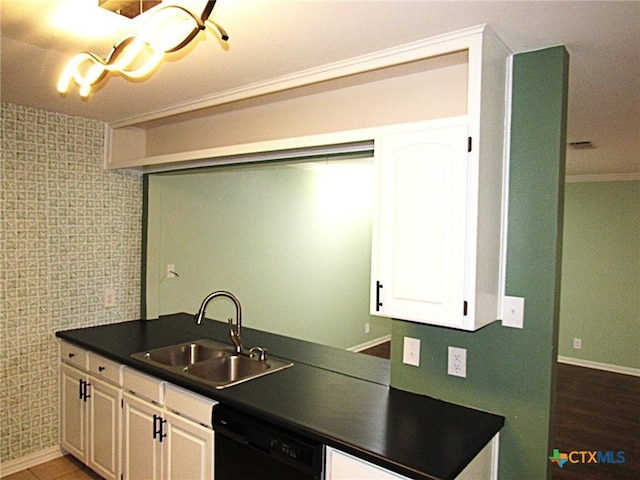 kitchen featuring dark countertops, black dishwasher, white cabinets, and a sink