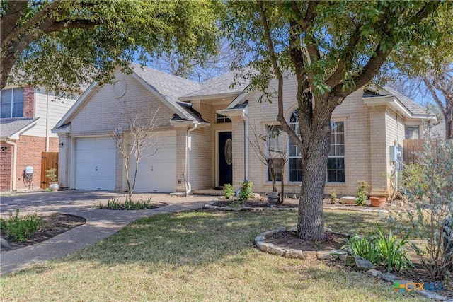 view of front of house featuring a garage, driveway, brick siding, fence, and a front yard