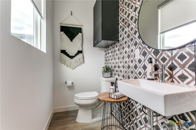 bathroom with decorative backsplash, wood-type flooring, sink, and toilet