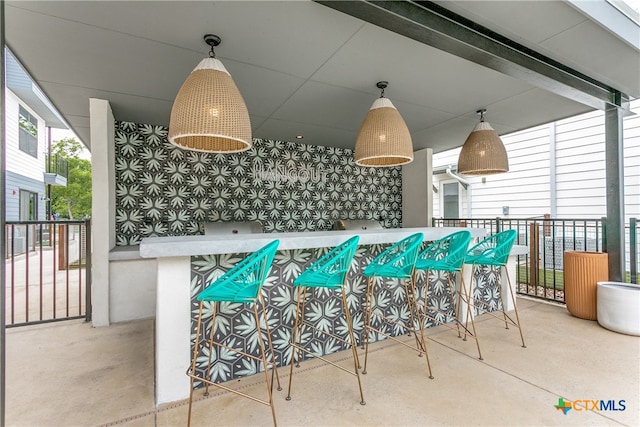 view of patio featuring ceiling fan and exterior bar