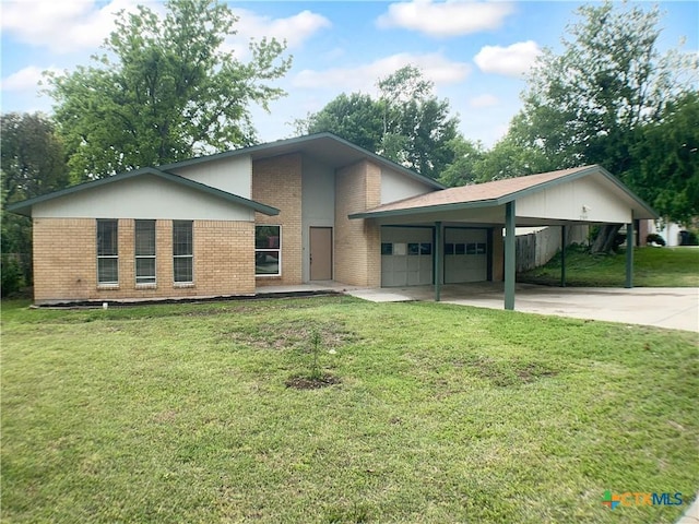 view of front of house with an attached garage, a front yard, driveway, and brick siding
