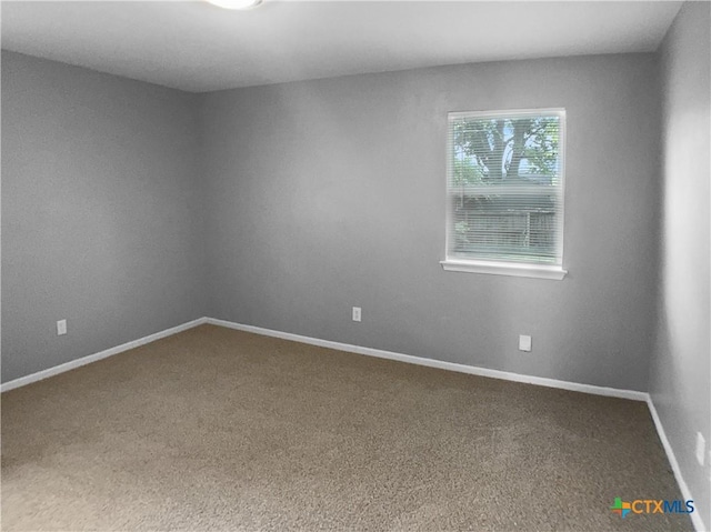 carpeted empty room with baseboards