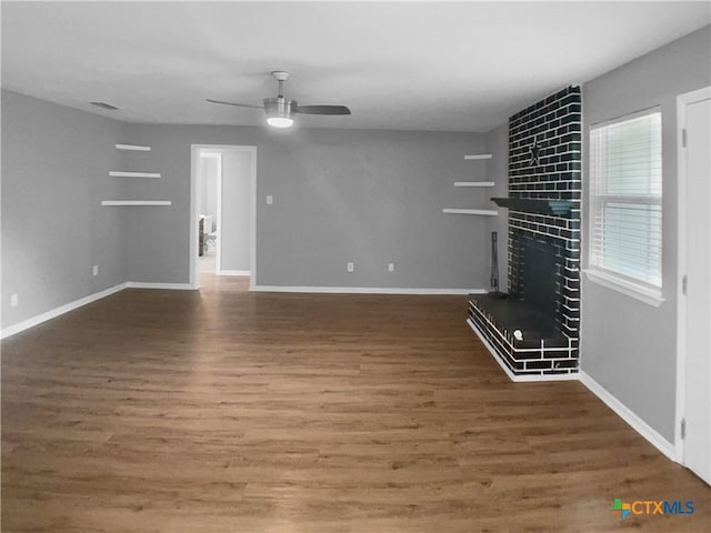 unfurnished living room with a ceiling fan, baseboards, and wood finished floors