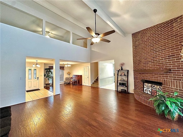 209 Westbrook Dr, Victoria, TX 77904 - living area featuring ceiling fan, wood finished floors, a fireplace, stairway, and beam ceiling