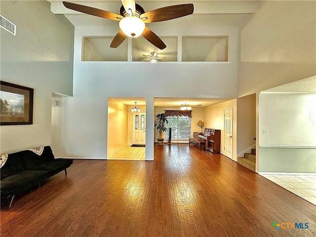 209 Westbrook Dr, Victoria, TX 77904 - living room with wood finished floors, a high ceiling, stairway, a ceiling fan, and a chandelier