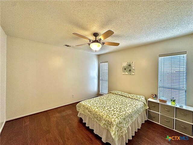 209 Westbrook Dr, Victoria, TX 77904 - bedroom with dark wood-type flooring, a textured ceiling, and a ceiling fan