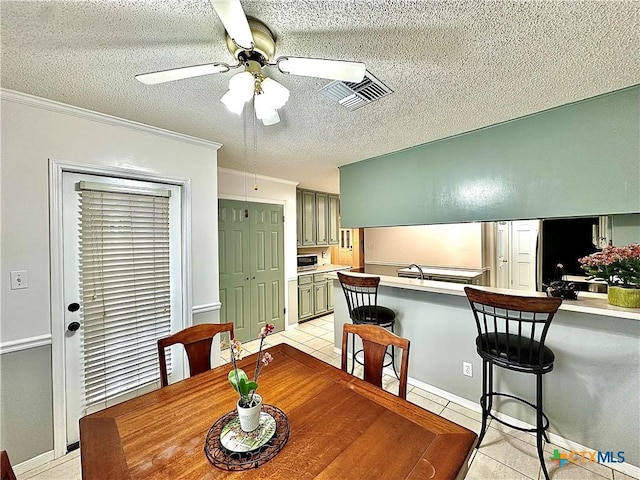 209 Westbrook Dr, Victoria, TX 77904 - dining space with light tile patterned flooring, a ceiling fan, a textured ceiling, and ornamental molding