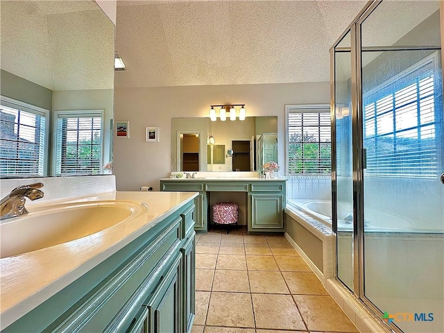 209 Westbrook Dr, Victoria, TX 77904 - full bathroom featuring plenty of natural light, a textured ceiling, two vanities, a garden tub, and a stall shower