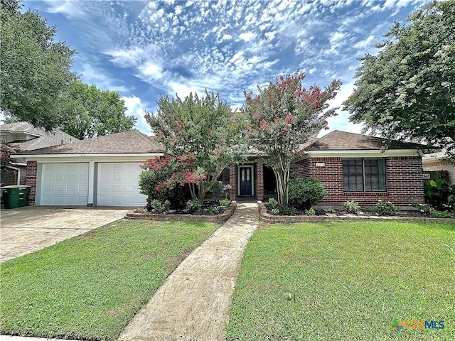 209 Westbrook Dr, Victoria, TX 77904 - view of front facade featuring brick siding, a front lawn, concrete driveway, and a garage