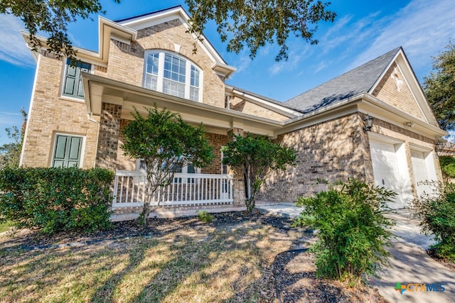 view of front of property featuring covered porch and a garage