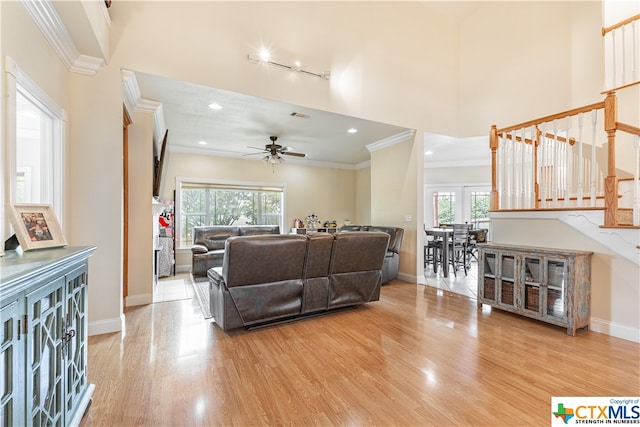 living room with hardwood / wood-style floors, ceiling fan, and crown molding