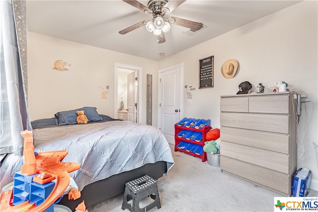 carpeted bedroom featuring ceiling fan and ensuite bath