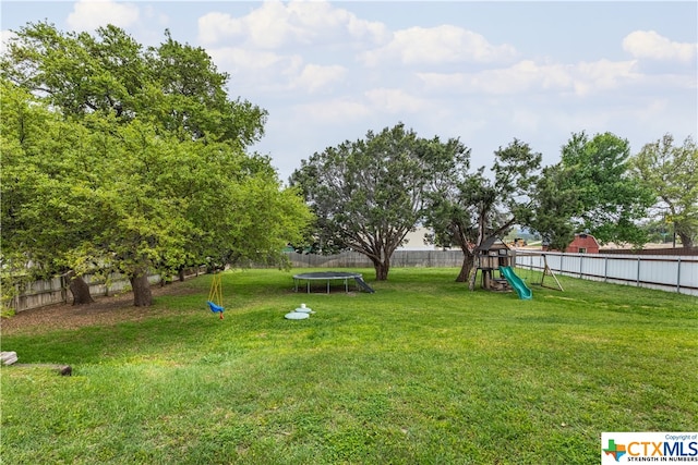 view of yard with a playground and a trampoline