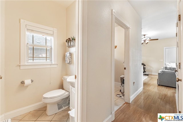 bathroom featuring toilet, hardwood / wood-style flooring, and ceiling fan