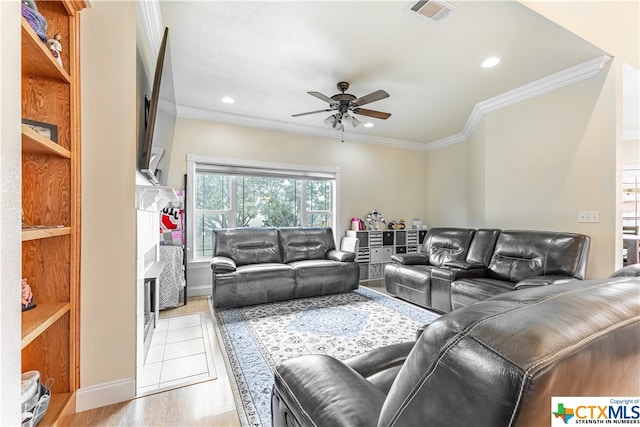 living room featuring light hardwood / wood-style floors, ceiling fan, and crown molding