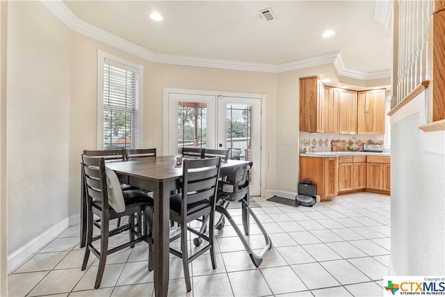 dining space with french doors, light tile patterned floors, and crown molding