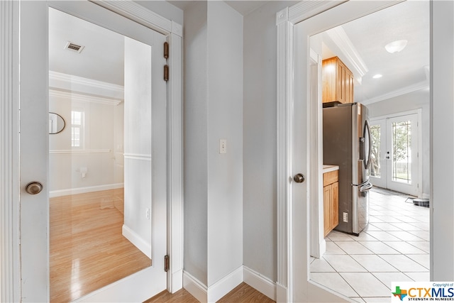 corridor featuring light hardwood / wood-style flooring, french doors, and ornamental molding