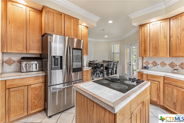 kitchen featuring black electric cooktop, light tile patterned floors, stainless steel fridge with ice dispenser, a kitchen island, and backsplash