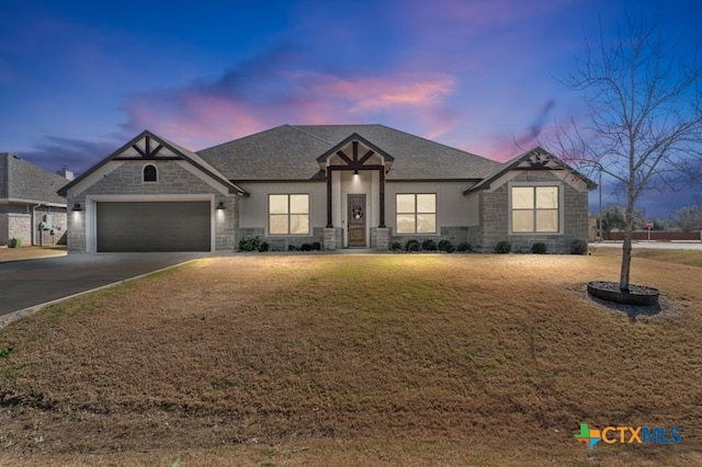 view of front of property featuring a garage and a lawn