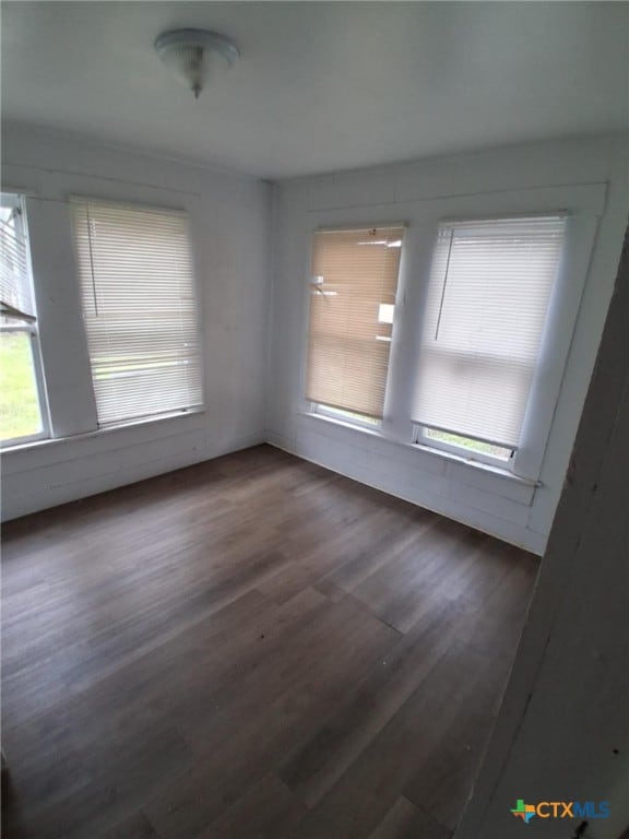 spare room with wood finished floors and plenty of natural light