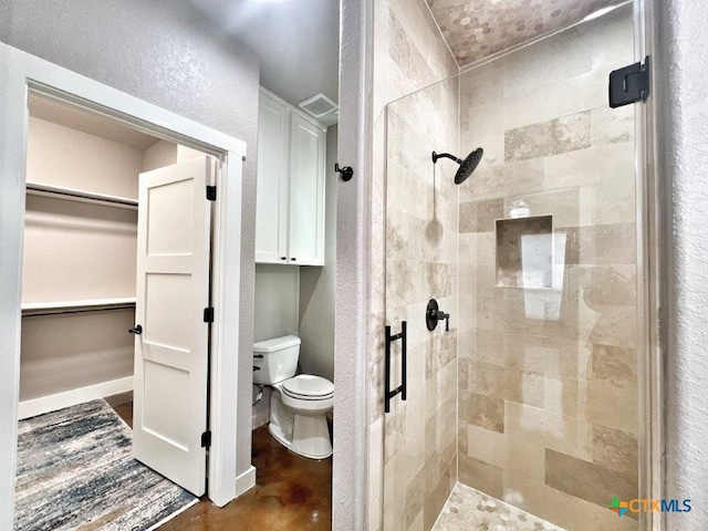 bathroom featuring toilet and a shower with door