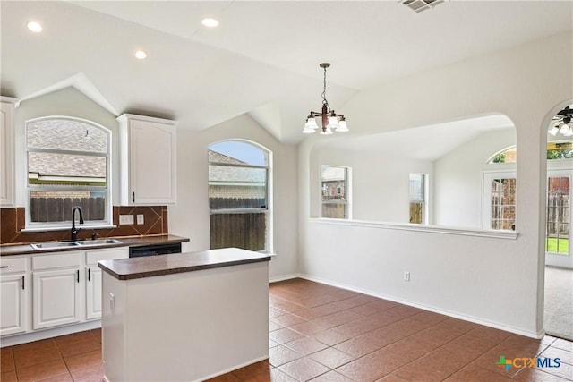 2010 Schorn Dr, Killeen, TX 76542 - kitchen with vaulted ceiling, plenty of natural light, dark countertops, backsplash, and white cabinetry