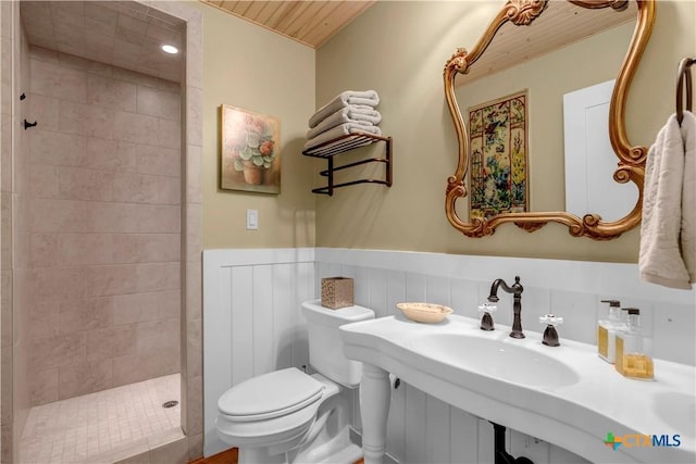 bathroom featuring a tile shower and toilet