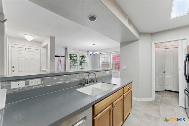 326 Trestle Tree, San Marcos, TX 78666 - kitchen featuring a sink, a chandelier, baseboards, pendant lighting, and dark countertops