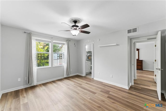 326 Trestle Tree, San Marcos, TX 78666 - unfurnished bedroom featuring light wood-style floors, baseboards, a ceiling fan, and ensuite bath