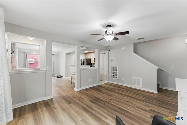 326 Trestle Tree, San Marcos, TX 78666 - unfurnished living room featuring a ceiling fan, stairs, baseboards, and wood finished floors