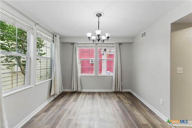 326 Trestle Tree, San Marcos, TX 78666 - unfurnished dining area with wood finished floors, a chandelier, healthy amount of natural light, and baseboards
