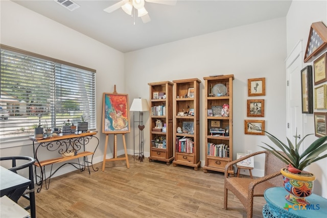 living area with ceiling fan and light hardwood / wood-style floors