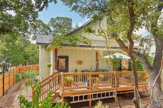 rear view of property featuring a wooden deck