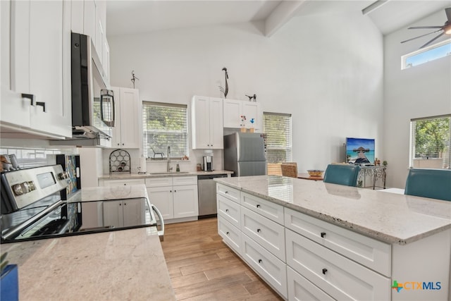 kitchen with white cabinetry, appliances with stainless steel finishes, a wealth of natural light, sink, and light hardwood / wood-style flooring