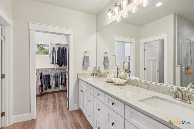 bathroom featuring vanity, hardwood / wood-style floors, and a shower with shower door