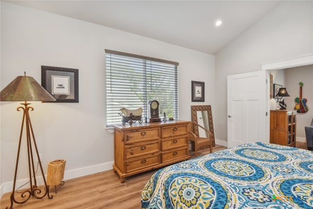 bedroom featuring high vaulted ceiling and light hardwood / wood-style flooring