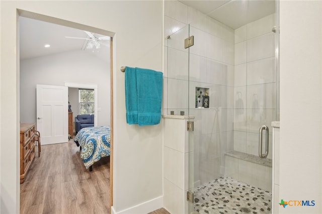 bathroom with lofted ceiling, hardwood / wood-style floors, a shower with door, and ceiling fan