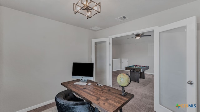 home office featuring carpet and ceiling fan with notable chandelier