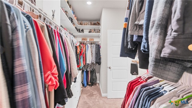 walk in closet featuring light colored carpet