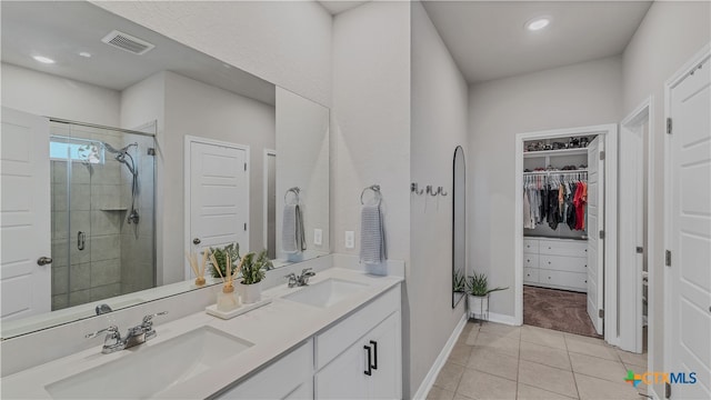 bathroom featuring tile patterned flooring, vanity, and a shower with shower door