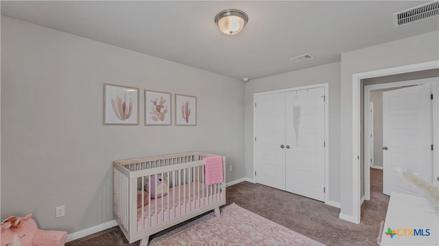 carpeted bedroom featuring a closet and a crib