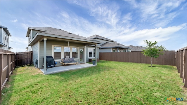 rear view of house featuring a patio area and a lawn