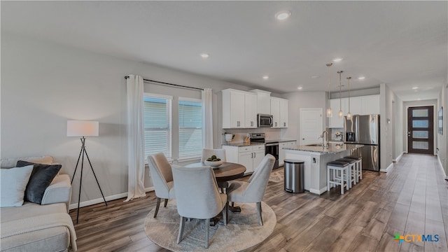 dining space with wood-type flooring and sink