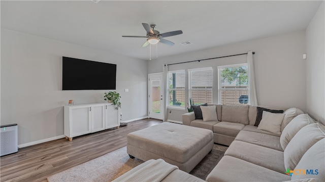 living room with light hardwood / wood-style flooring and ceiling fan