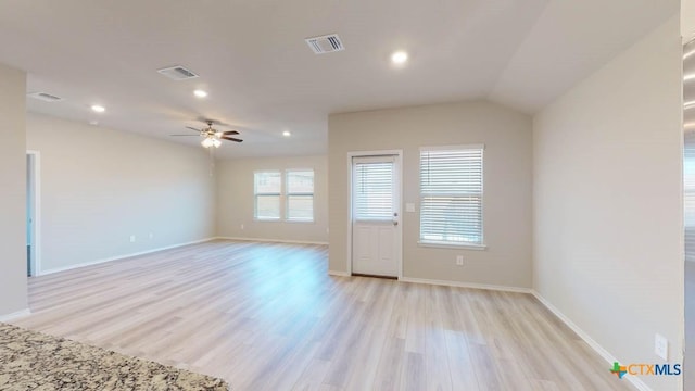 empty room with light hardwood / wood-style flooring, ceiling fan, and vaulted ceiling