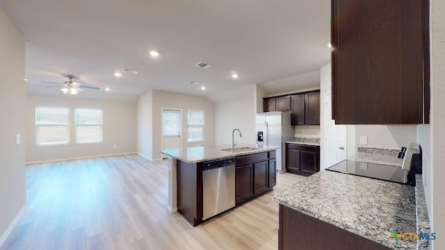 kitchen with sink, appliances with stainless steel finishes, a kitchen island with sink, dark brown cabinets, and light hardwood / wood-style floors