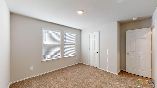 unfurnished bedroom with a closet and light carpet