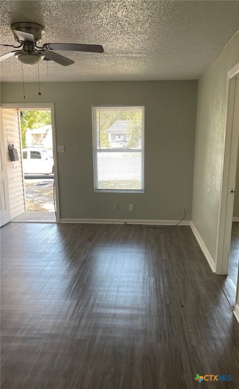 unfurnished room featuring dark hardwood / wood-style floors, ceiling fan, and a textured ceiling